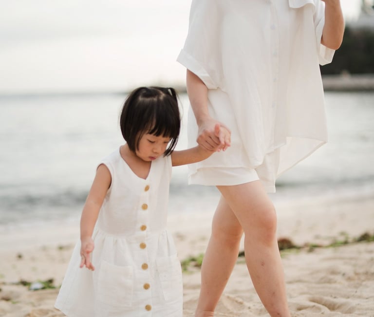 Mother walking with daughter along the beach during a family photography session at The Mulia Nusa Dua Bali