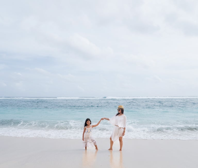Family walking together by the ocean at Karma Kandara Bali in a wide scenic view  