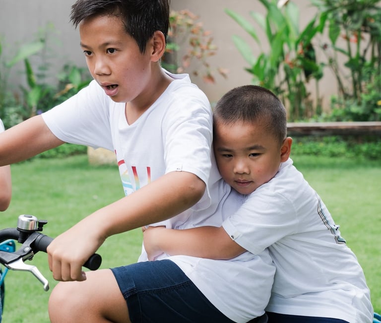 Child riding bicycle during extended family photography at Lumbini Villas Jimbaran Bali with natural candid moment
