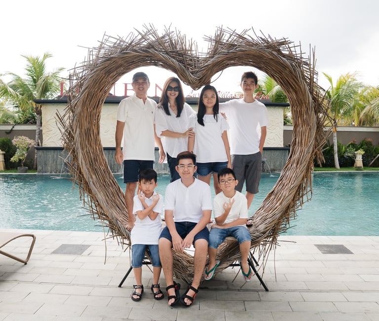 Family portrait inside heart frame during extended family photography at Lumbini Villas Jimbaran Bali by the pool