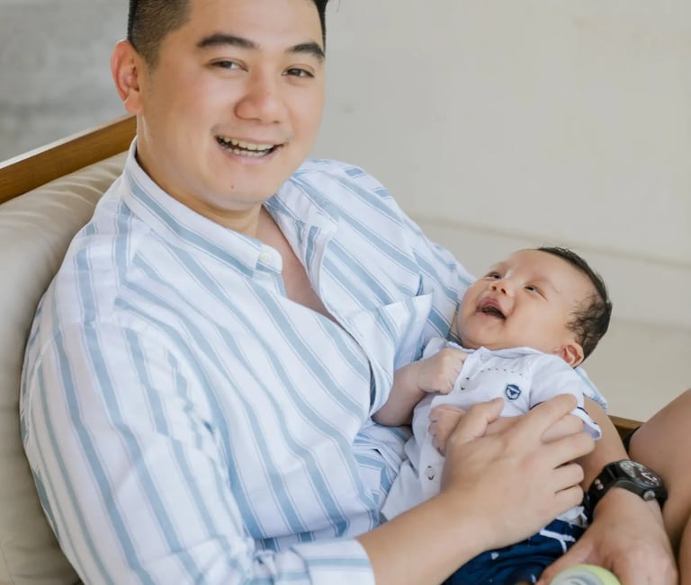 Father holding his baby during a family photography session at Samabe Bali Suites & Villas in Nusa Dua.
