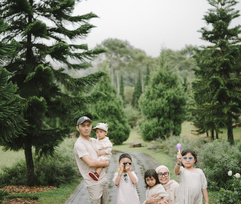 Family portrait with tall pine trees during a family photography session at Bali Farm House Bedugul Bali.