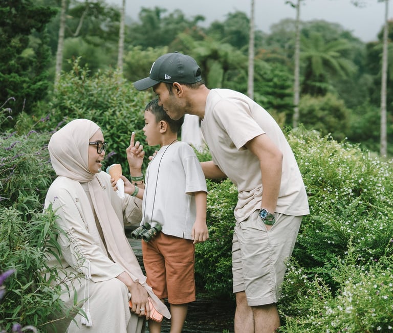 Father kissing mother during a family photography session at Bali Farm House Bedugul Bali.