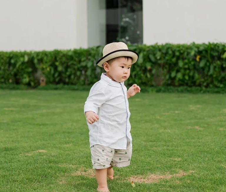 Baby playing on lawn at Alila Seminyak Bali during relaxed luxury family photography session.