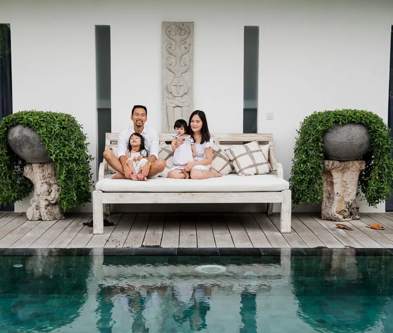 Family relaxing by the pool at a private villa in Seminyak Bali.