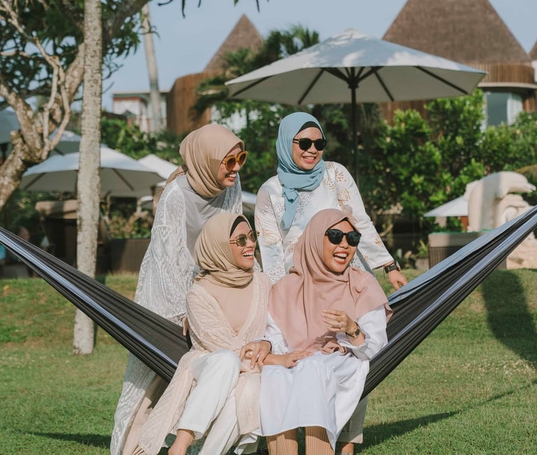 Friends sitting together on hammock during photoshoot at Candi Beach Resort Karangasem Bali