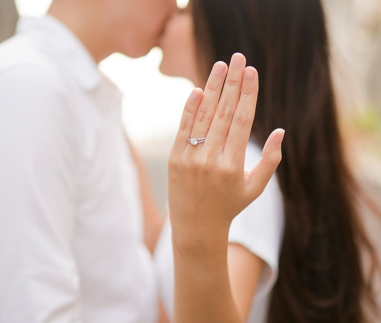 Couple kissing while showing engagement ring during proposal at Melasti Beach Bali
