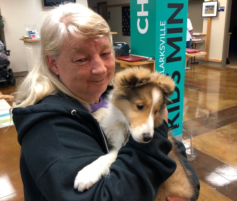 Tender Paws member Beth, holding puppy in her arms.