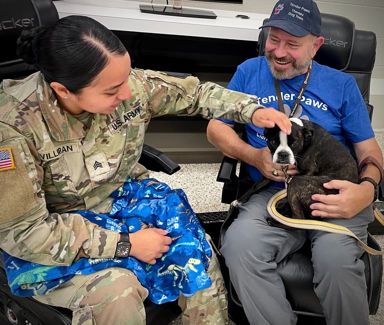 A female Soldier interacts with Tender Paws Therapy Dog Piper and her Handler, FDavid.
