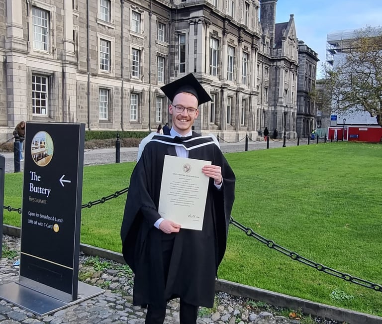 a man in a graduation gown holding a diploma certificate