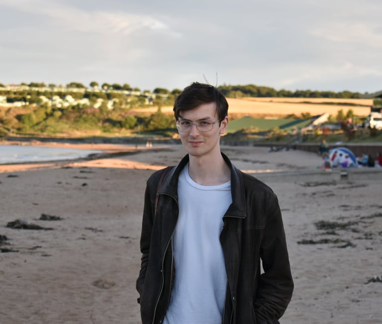 a man standing on a beach with a surfboard