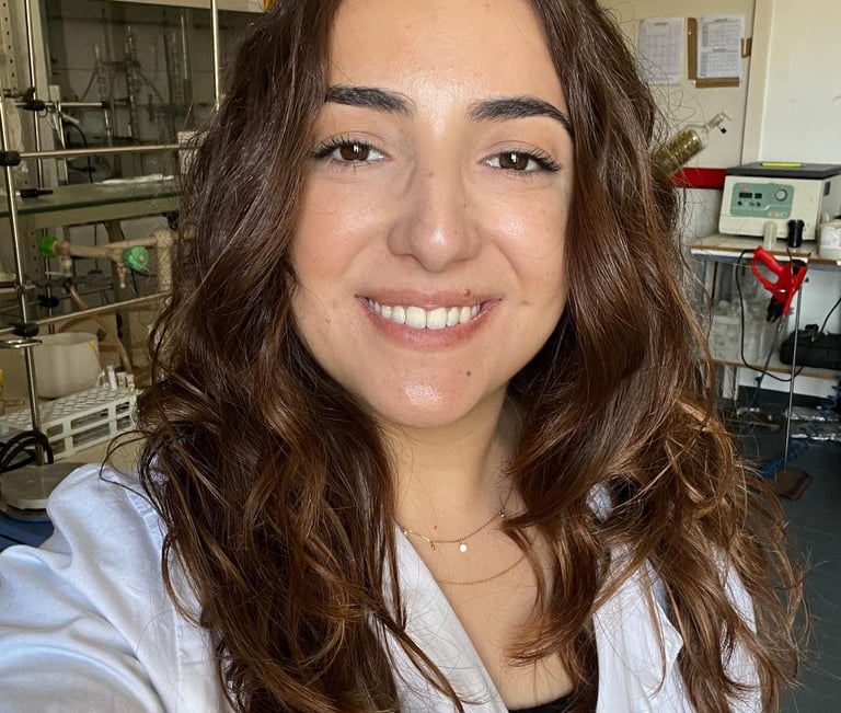 a woman in a lab coat smiling and holding a camera