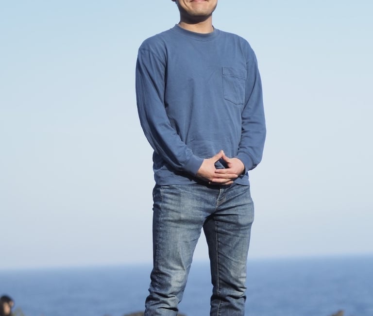 a man standing on a rock with his hands on his hips