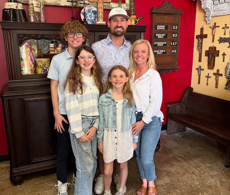 a photo of the family that owns race ready events standing in front of a bright red backdrop