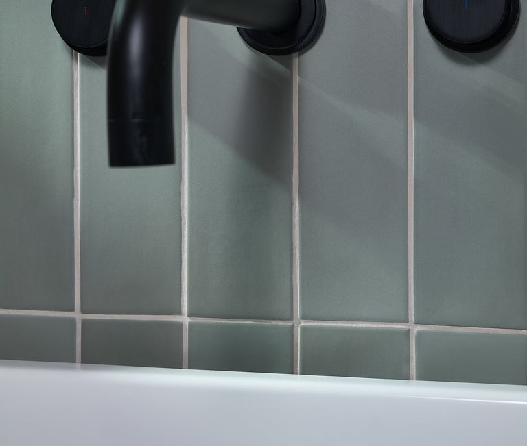 blue vertical tile with white grout and black bath tap 