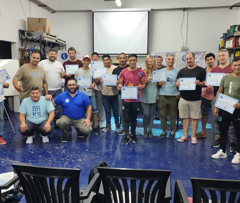 a group of people standing around a table with certificates. , Entrega de Certificados en ICL