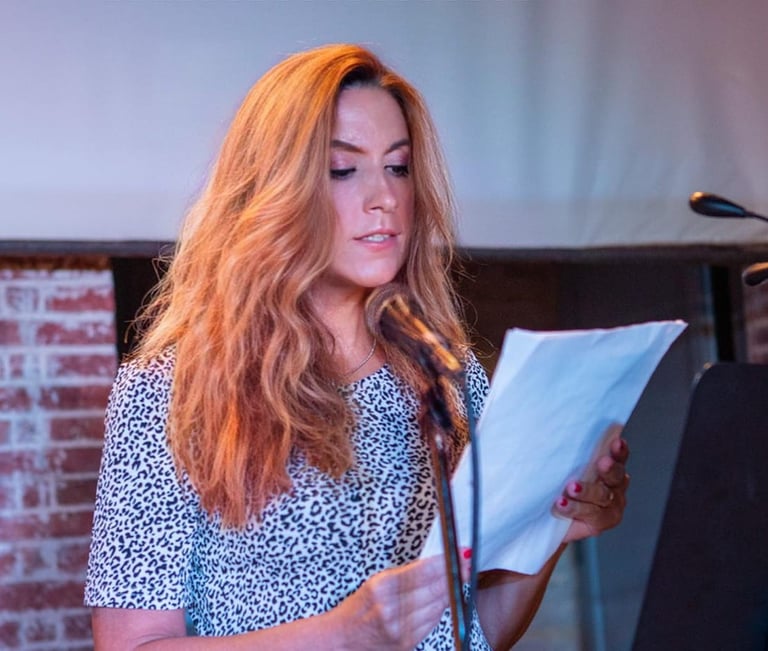 a woman reading a book and holding a microphone