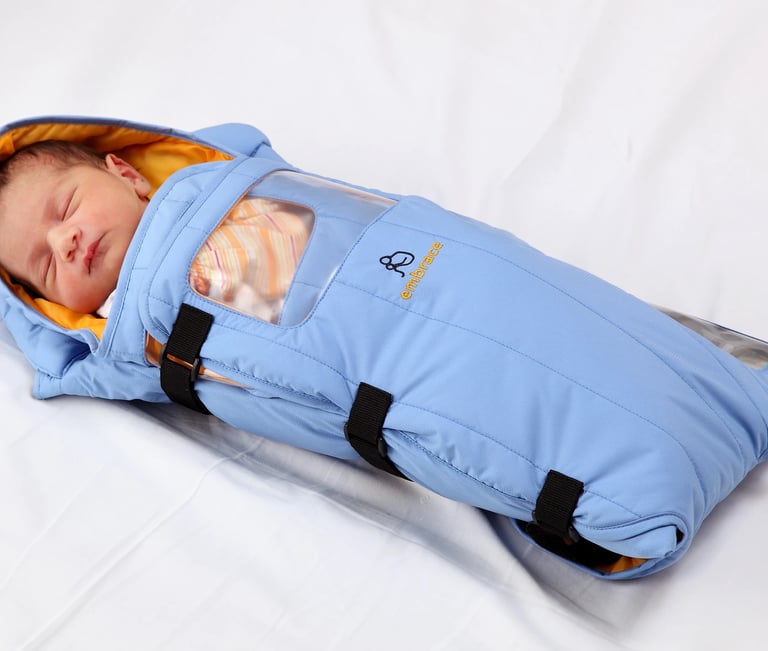 a baby in a portable infant incubator by Embrace Global