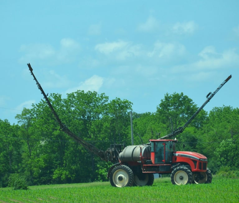 an image of a high clearance sprayer preparing to weed and feed a crop