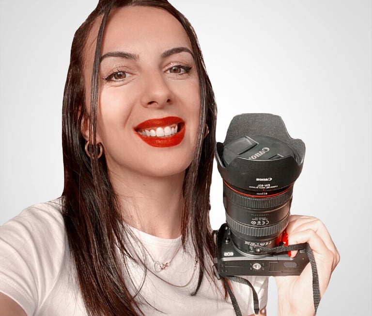 a woman holding a camera and smiling