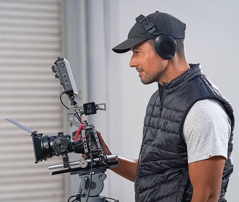 a man in a black vest and a camera with rode wireless pro