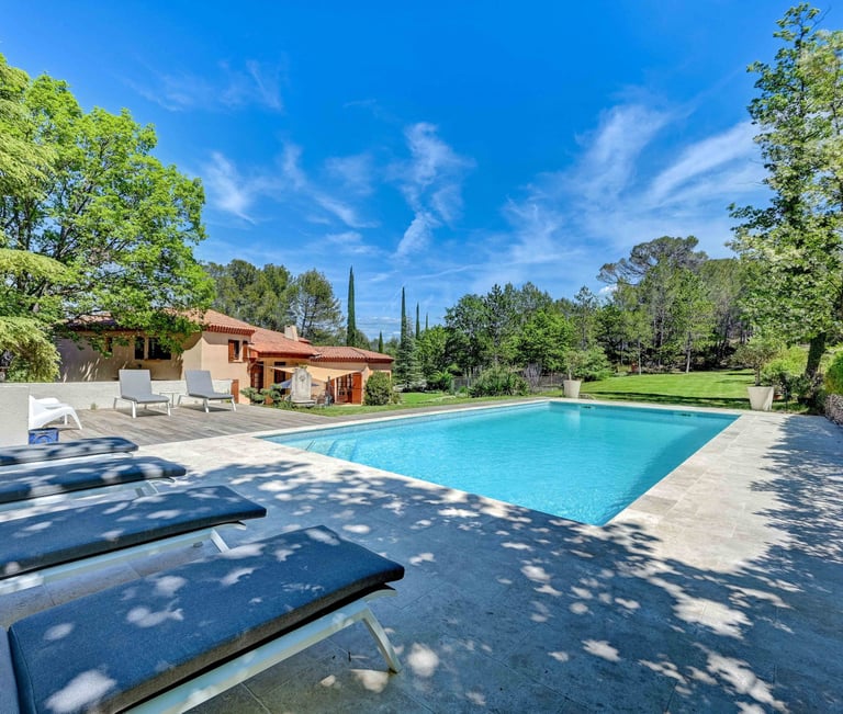 a pool with lounge chairs and a pool