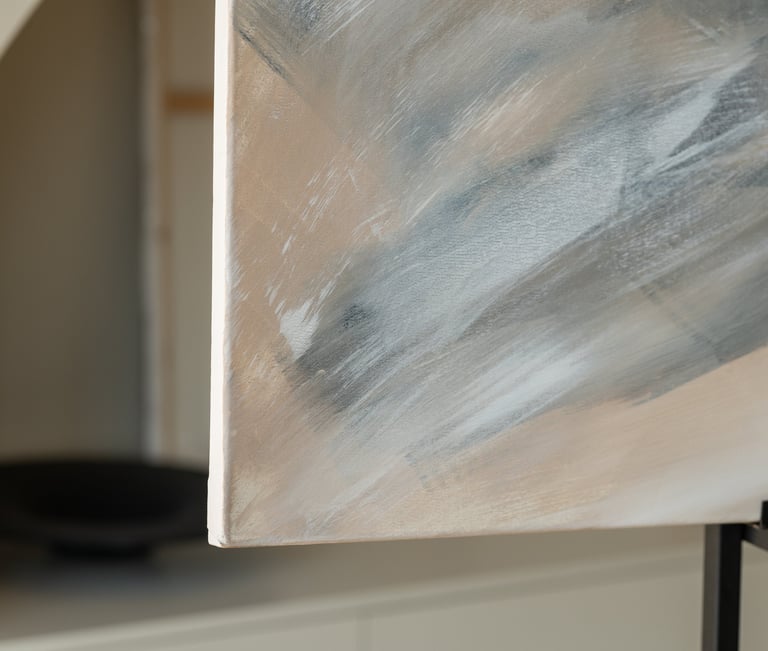 Close-up of an abstract acrylic painting featuring neutral grey, white, and beige brushstrokes on canvas.
