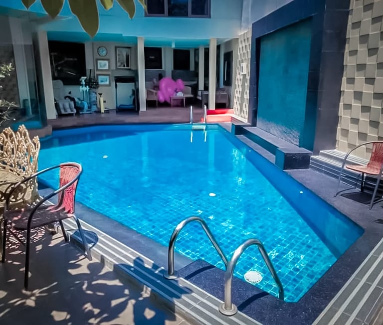 Kolam renang di belakang rumah dengan keramik berwarna biru yang sangat menyejukan.