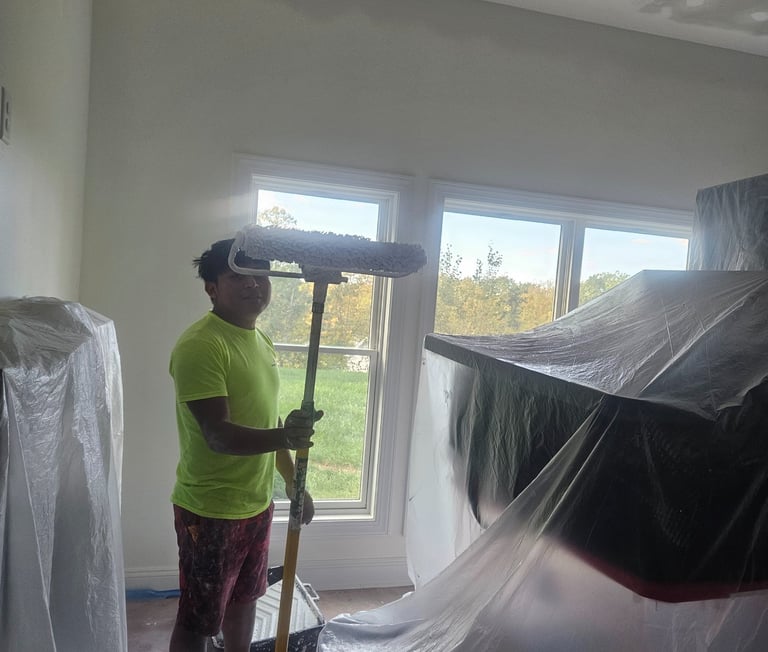 a man in a big room painting with a big roll!