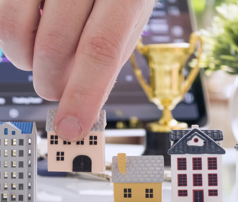 a person's hand is placing a house model of a house