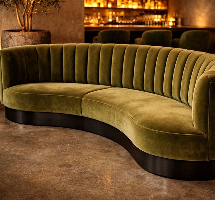 Custom curved olive green velvet banquette with channel tufting and sculptural base by Solo Home Decor
