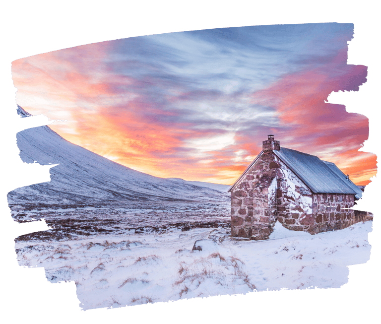 Snow-covered Cairngorm mountains in winter as the sun sets over the Highlands