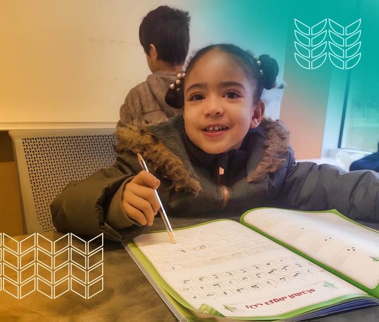 a young girl is smiling and holding a pen and writing on a notebook