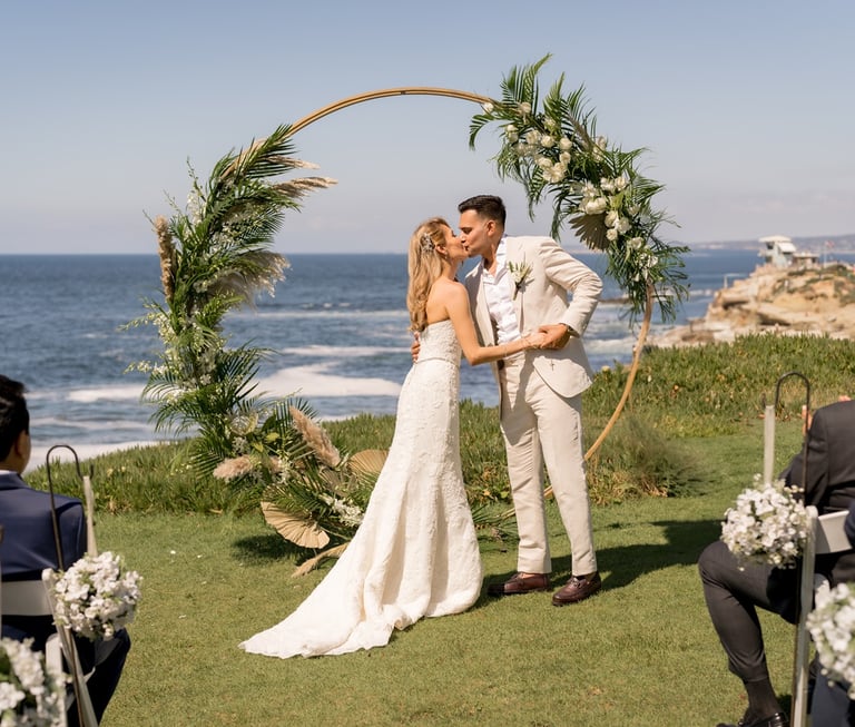 couple kissing in front of a circle wedding arbor at Cuvier Park, the wedding bowl, @sddweddings