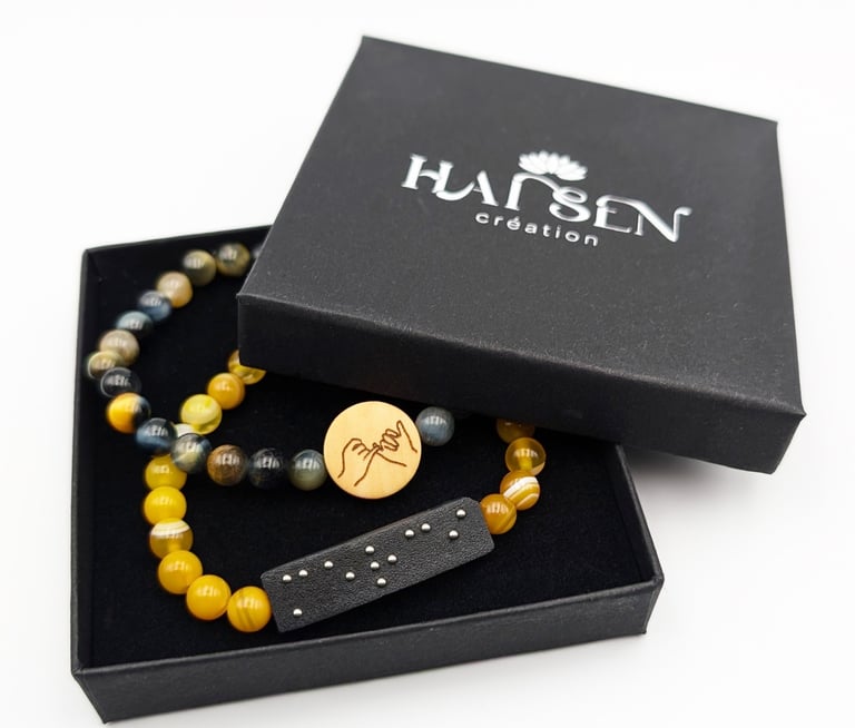 2 Bracelets un avec plaque braille Merci et un avec un cabochon avec le symbole amitié.