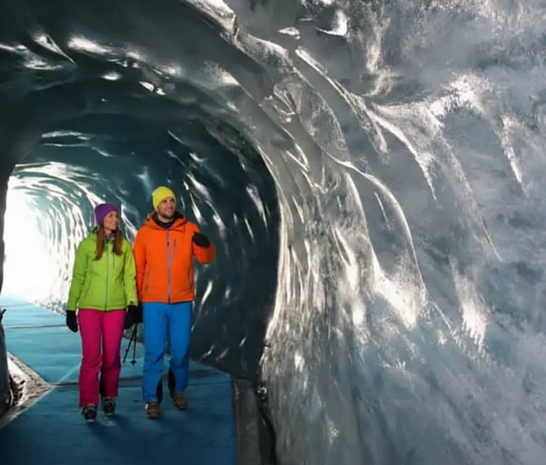 Couple exploring blue ice tunnels in Mer de Glace Ice Cave, Chamonix.