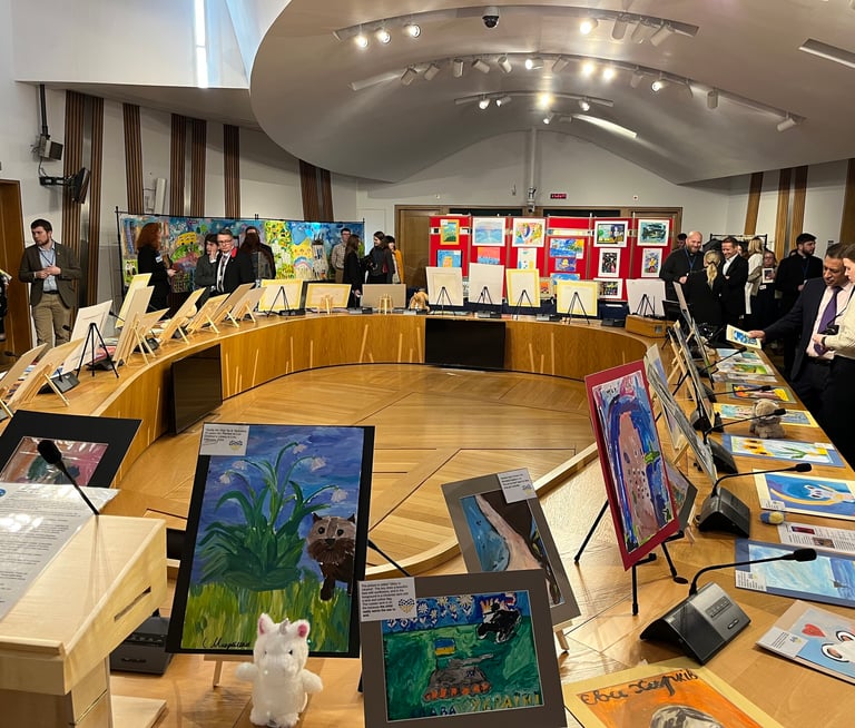 Politicians looking at the exposition with paintings created by children in the Ukrainian war