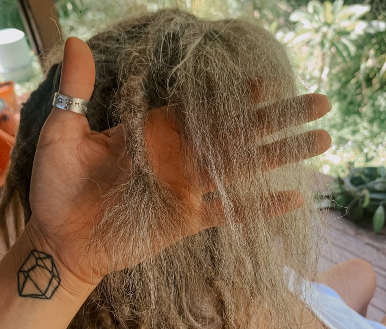 a woman who is getting her dreadlocks brushed out