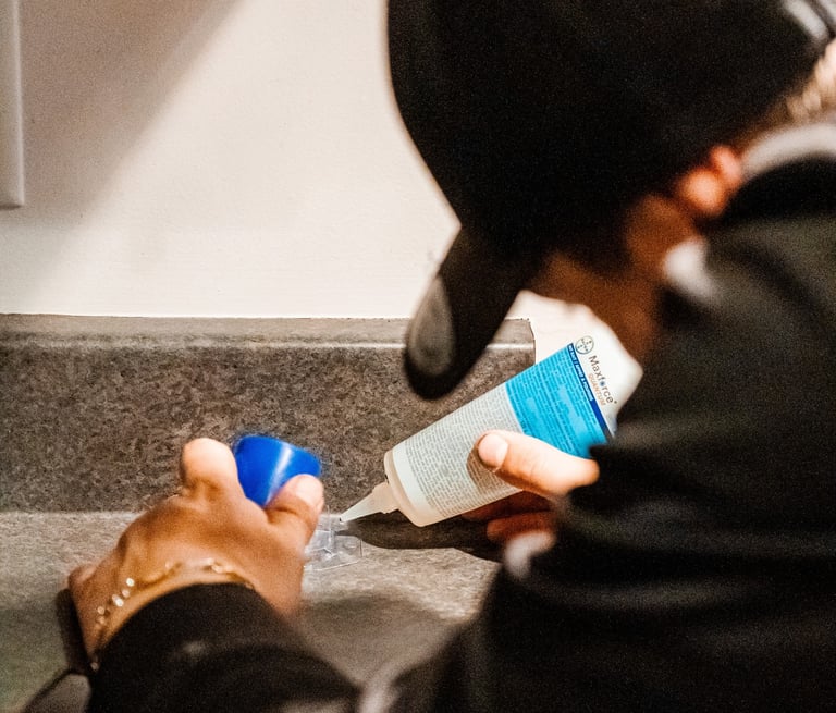 a man in a black jacket is holding a bottle of liquid