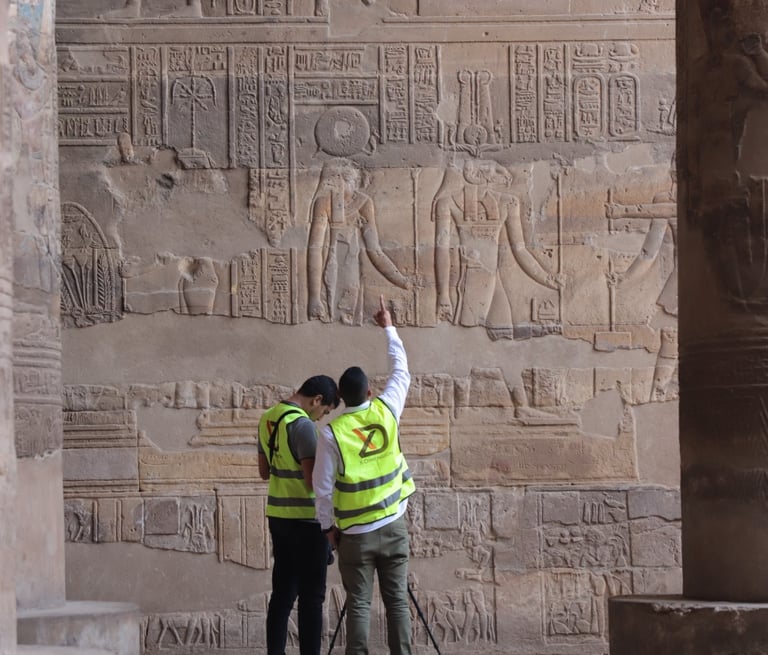X-Dimension in safety vests examine ancient Egyptian hieroglyphics and stone carvings at the Temple.