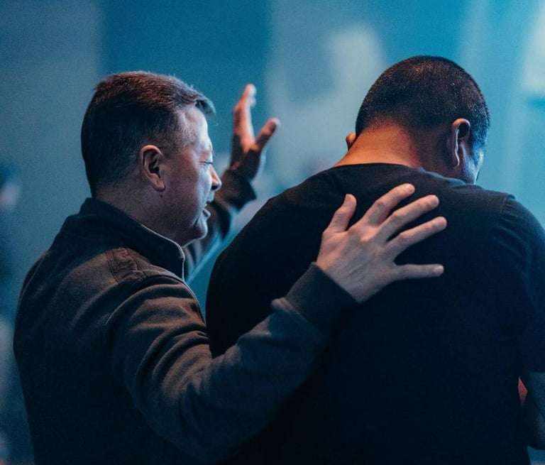 two men standing in a room with a praying 