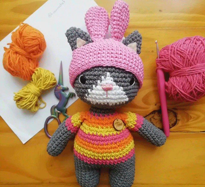 Un amigurumi de gatito con un sombrero rosa