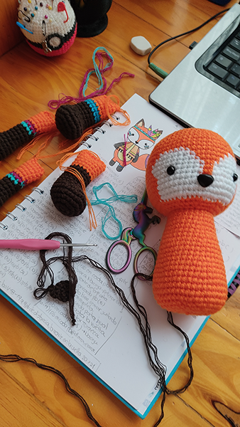 Un amigurumi de un zorrito desarmado, con las piezas listas para ser terminado