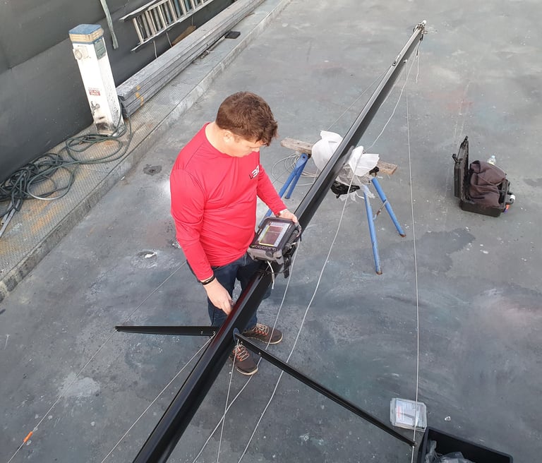 NDT technician performing ultrasonic testing on a yacht mast