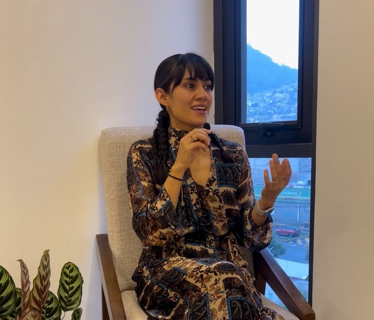 a woman sitting in a chair with a plant in front of a window