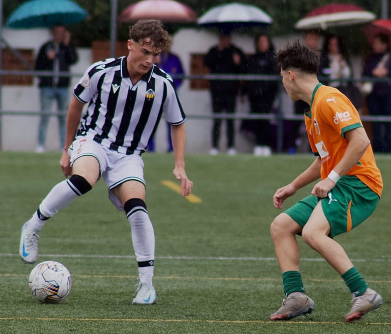 Dos jugadores de categoría juvenil nacional compitiendo por un balón, CD Castellón vs Valencia CF