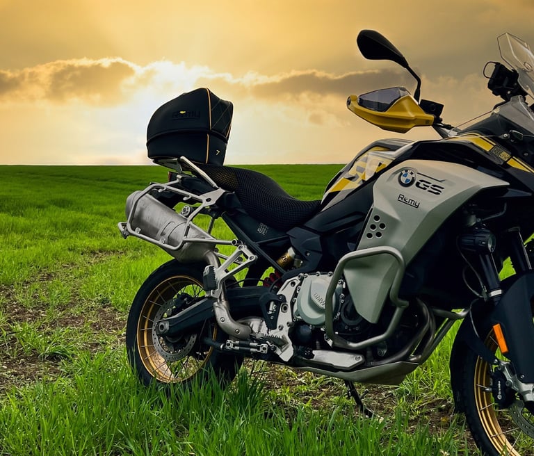 Remy Luxury Helmet Bag resting on a motorcycle seat with the sun setting in the background,