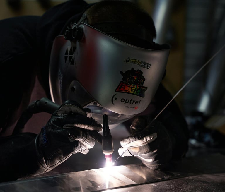 a man welding a metal object in a factory