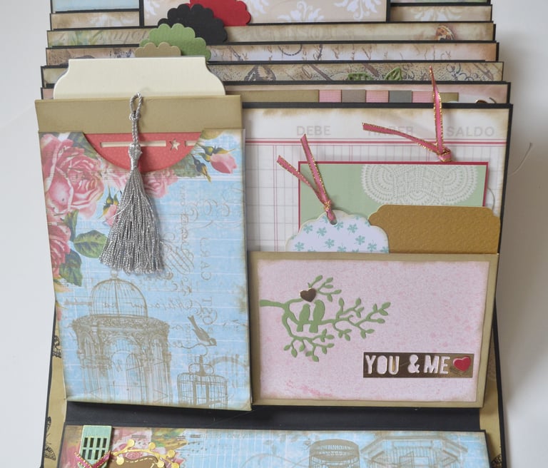 Handmade vintage scrapbook with decorative floral pockets, silver tassels, and paper tags for journaling.