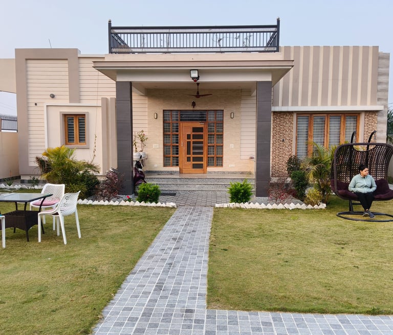 Modern luxury PG exterior with a stone path, green lawn, and comfortable outdoor patio furniture.